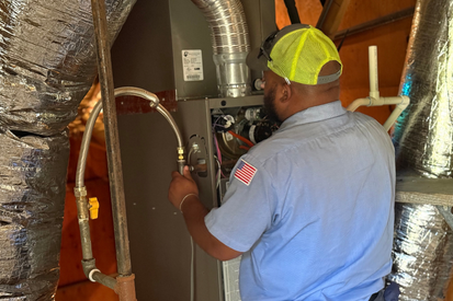 a Mauzy heating & air technician installing a new furnace